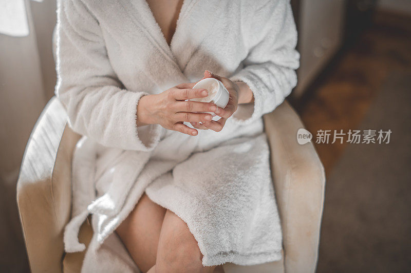 在腿上涂保湿霜的女人