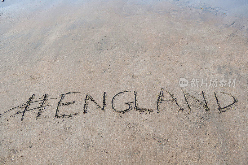 图片的标签标签写在阳光明媚的海滩上，英国的单词写在沙滩上，Palolem海滩，印度果阿，概念社交媒体照片的手写在金色的沙子与现代标签前缀
