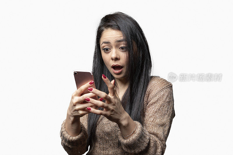 震惊的年轻女子看着智能手机的屏幕接收坏消息的肖像
