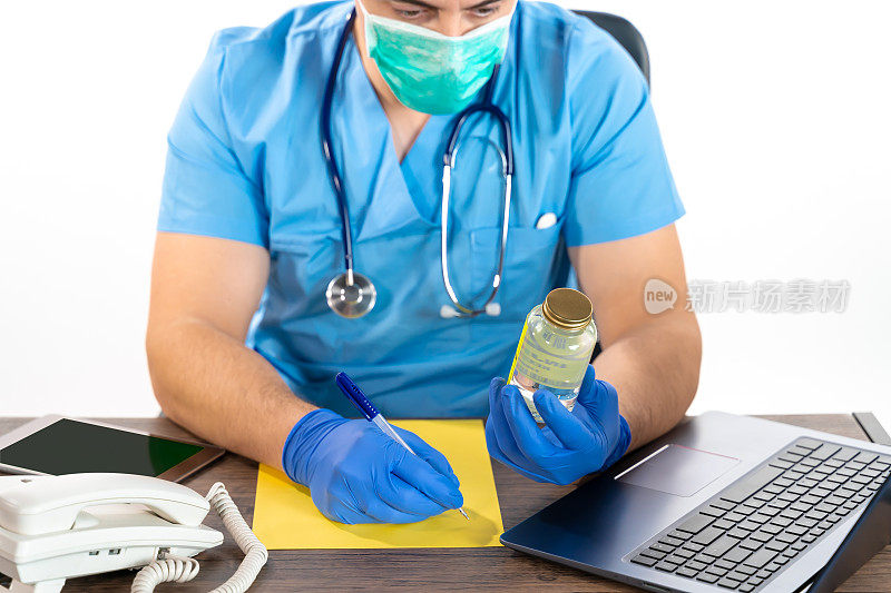 医生手持手术手套，手持冠状病毒疫苗瓶，在黄色空白纸上书写