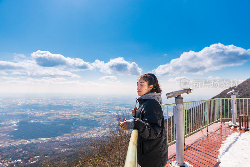 年轻女子从山上的观察点看风景