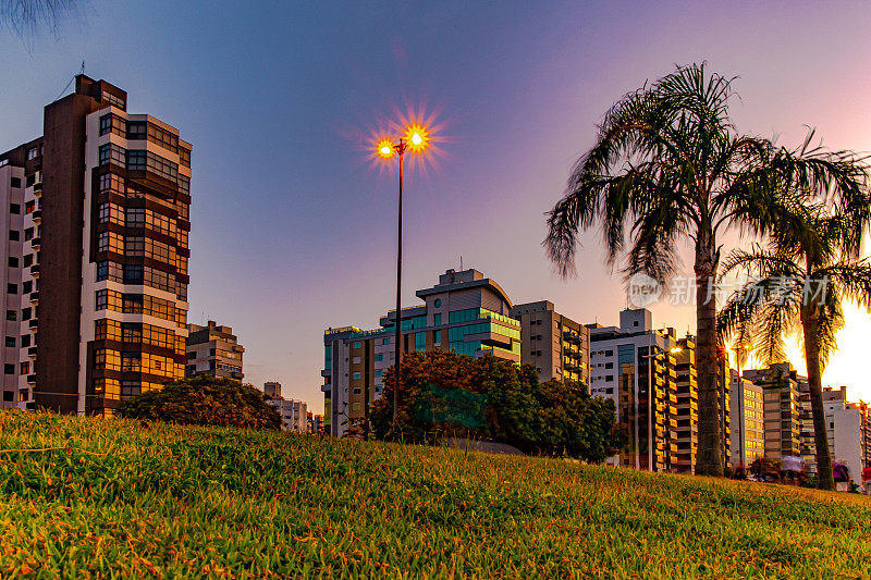 在Florianópolis的贝拉马尔大道的日落景观，与建筑反射在海上照明。