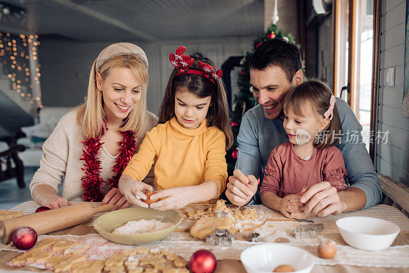 两个女孩和爸爸妈妈一起做圣诞饼干
