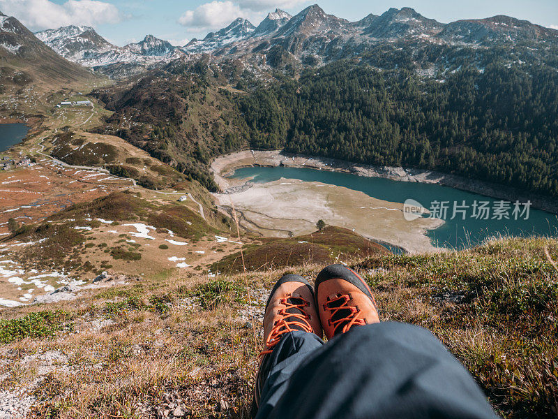 人的脚在山顶俯瞰高山湖泊