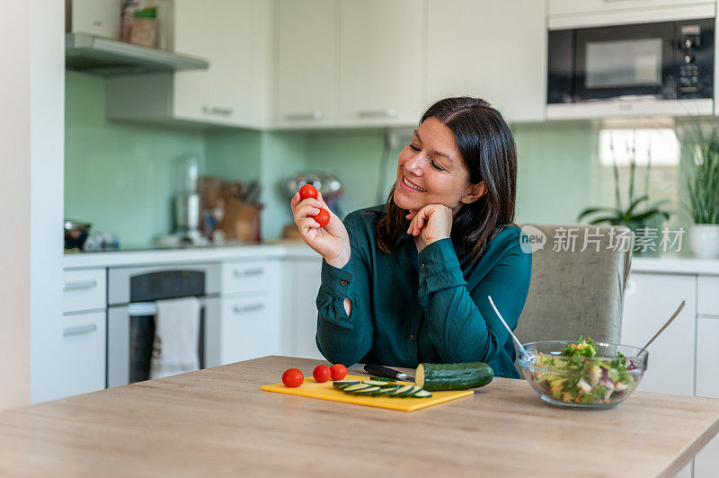 成年妇女在家庭厨房里准备健康食物