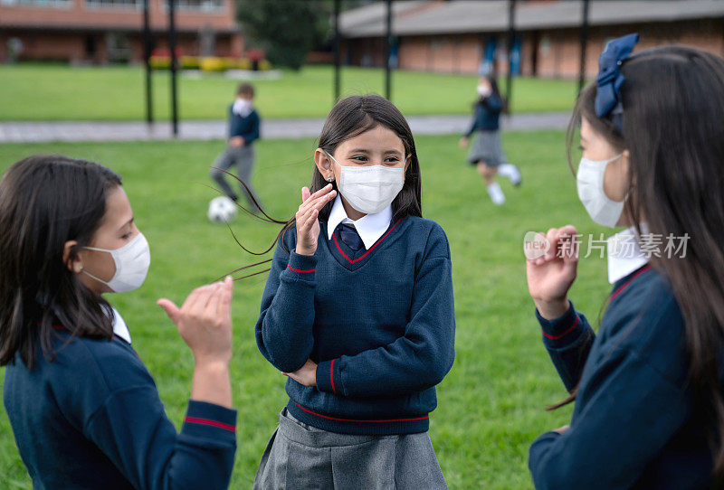 一群快乐的女孩在课间戴着面具在学校玩耍
