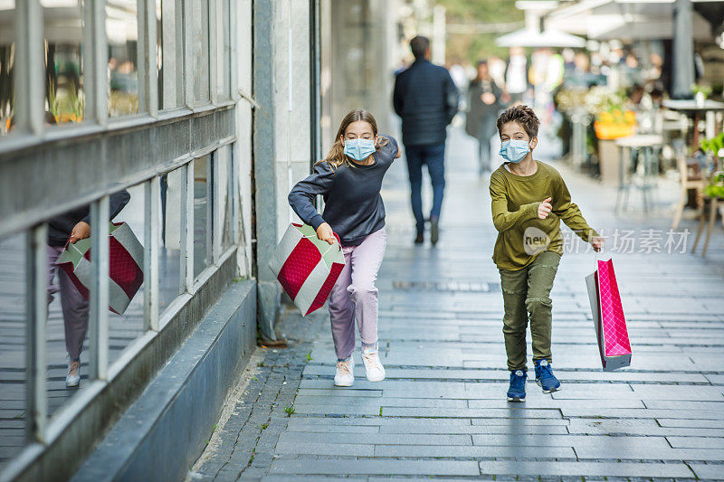 在流感大流行期间，快乐的孩子们一起在城市里度过购物日。