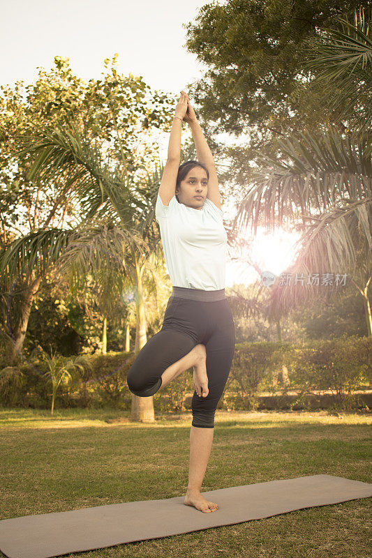 少女做瑜伽和锻炼在公园股票照片