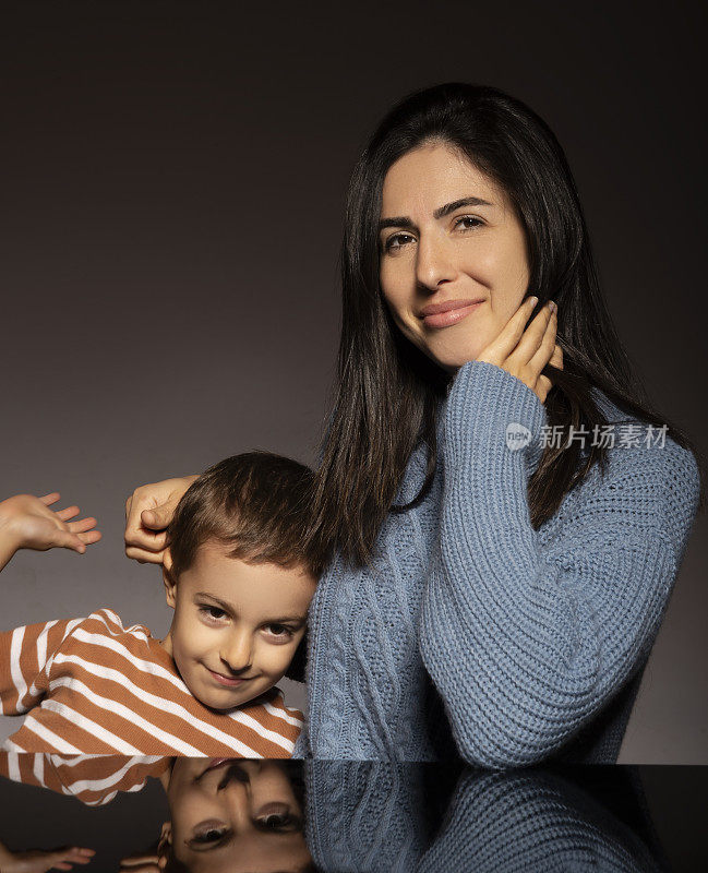 快乐的妈妈和害羞的儿子的肖像。