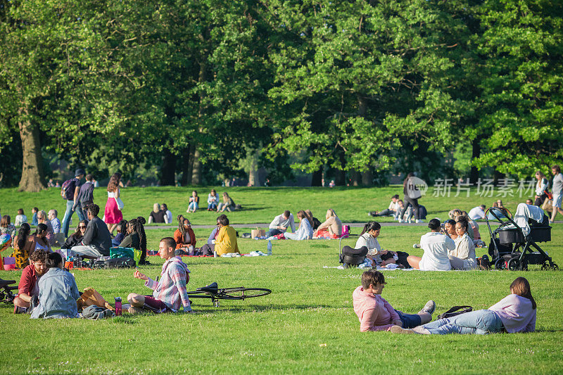 人们正在伦敦格林威治公园野餐，享受阳光明媚的一天