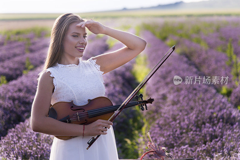 一位年轻迷人的女子在薰衣草田里摆姿势