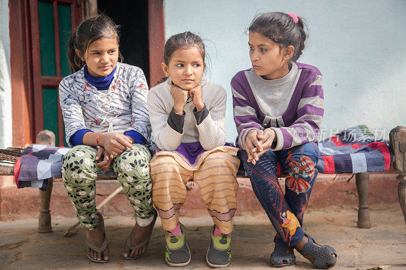 三个孩子坐在一起在印度的村庄。