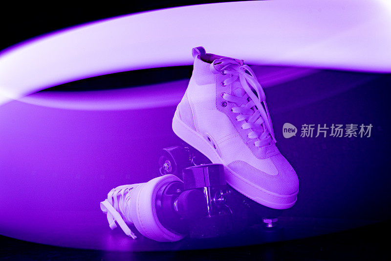 在黑色的背景下，溜冰鞋在迪斯科灯光下闪闪发光。