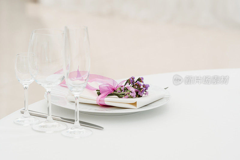 在派对婚礼上用鲜花装饰的盘子、叉和刀的特写。
