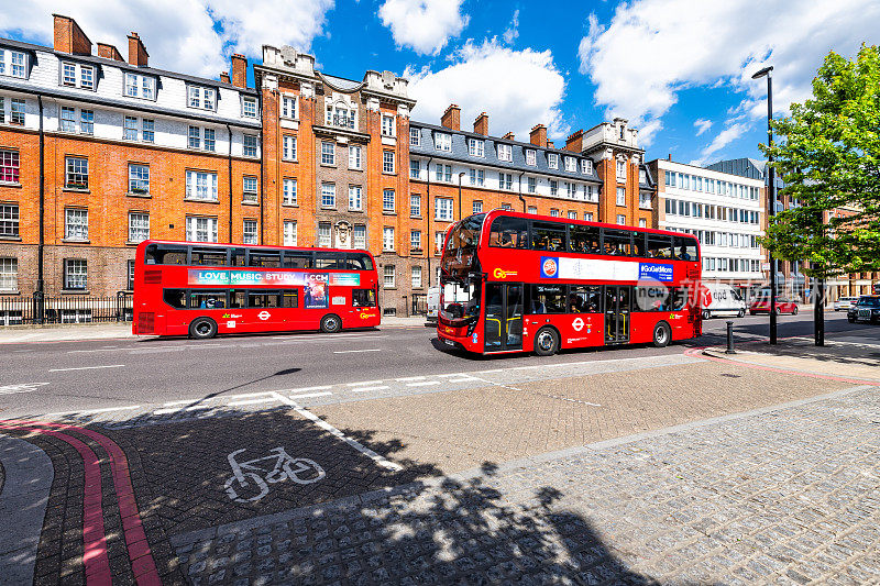 伦敦的两辆双层巴士，在沃克斯豪尔桥路贴着爱情音乐学习和披萨GoGo的广告