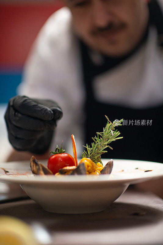 特写男厨师在餐厅装饰餐点