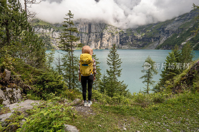 年轻女子徒步旅行在一个美丽的高山风景在夏天散步在瑞士阿尔卑斯山享受自然和户外