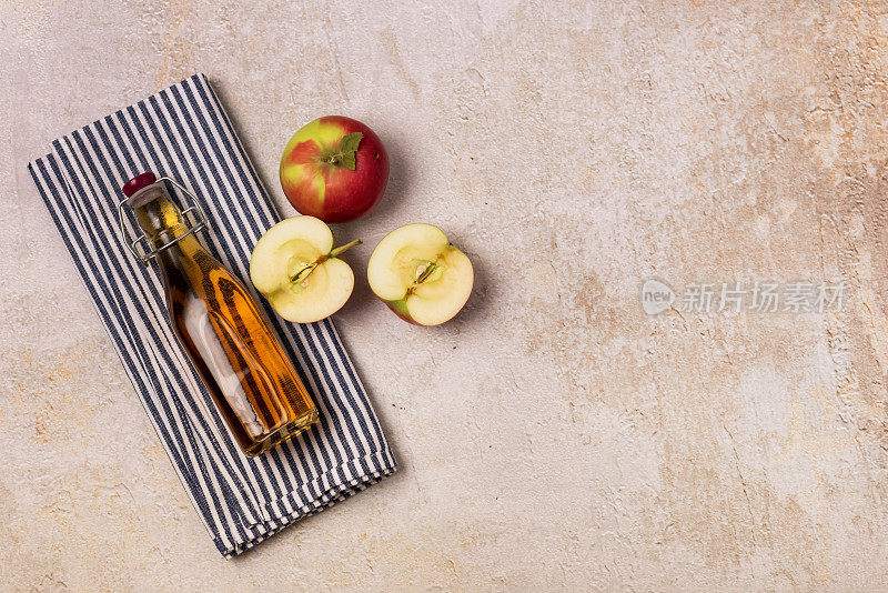 苹果苹果醋瓶餐巾生苹果混凝土背景俯视图拷贝空间