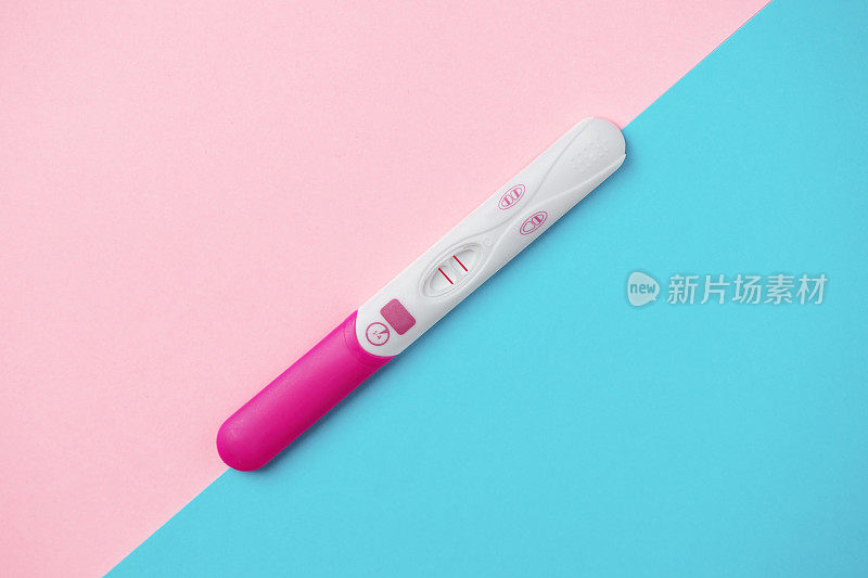 粉色和蓝色背景的妊娠检查呈阳性。妊娠检查结果阳性。