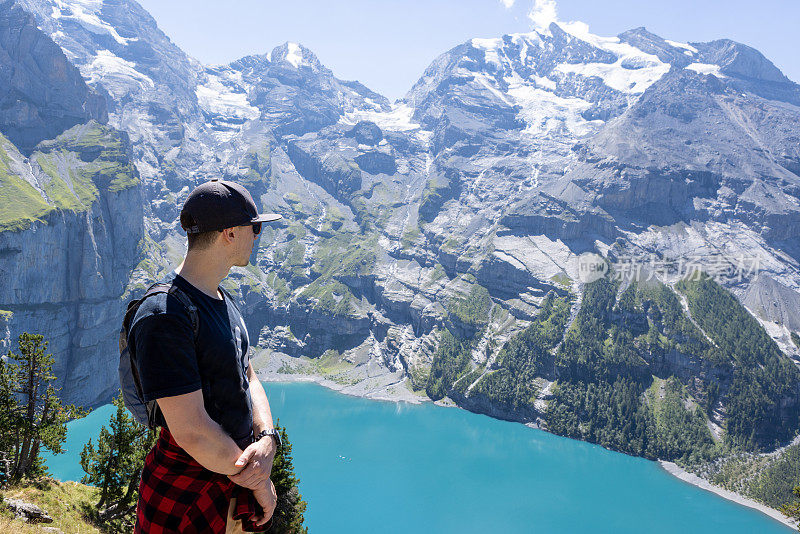 夏天，人们凝视着美丽的大自然，他在瑞士阿尔卑斯山徒步旅行