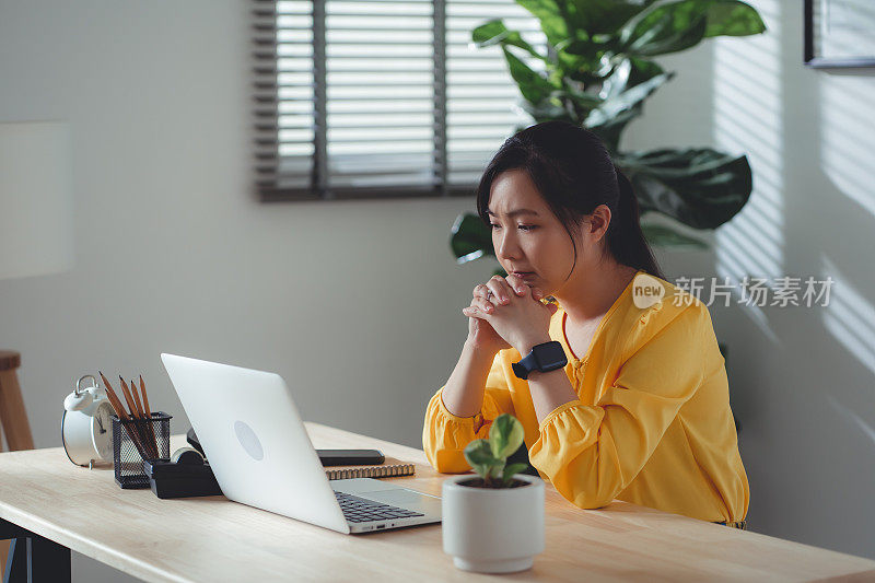 结婚后，坐在家里办公室的亚洲女性感到很难过。