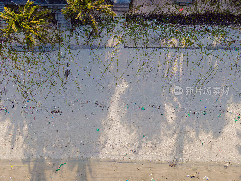 在碧绿海水的热带海滩上，塑料垃圾和医疗废物的沙滩-无人机拍摄的鸟瞰图