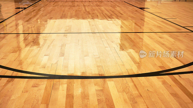 室内空旷的现代篮球室内运动场，半光涂层木地板，人工灯光反射