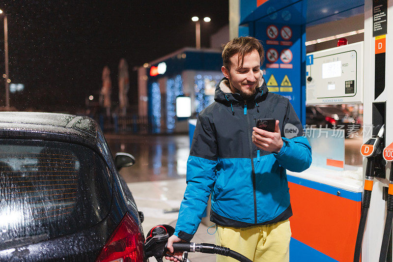 一个年轻人在晚上给他的柴油车加油