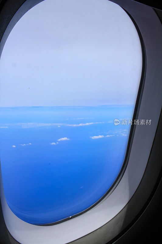 从飞机的窗户往外看。令人惊叹的云景和蓝天。坐飞机旅行。在路上。