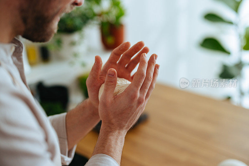 匿名男子用手把面团揉成一个球