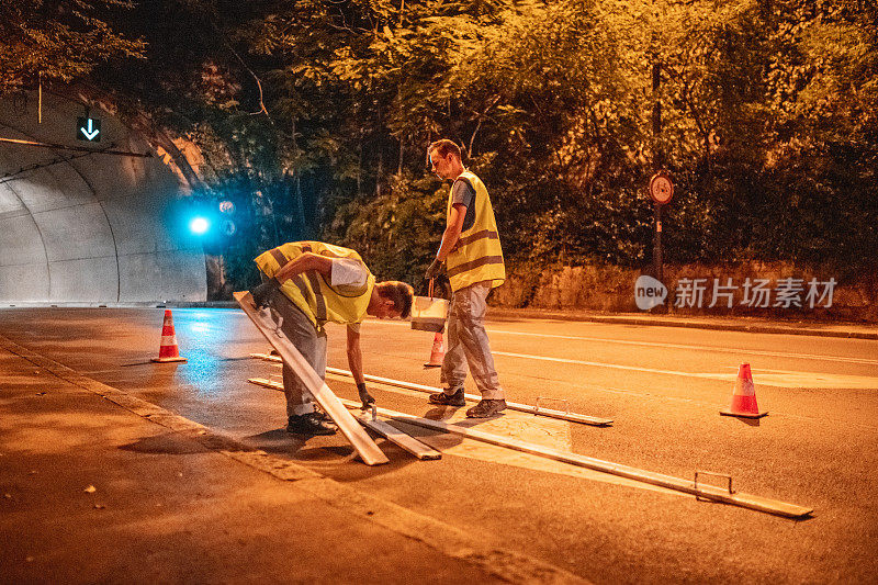 道路维修人员正在准备右转路标进行喷漆