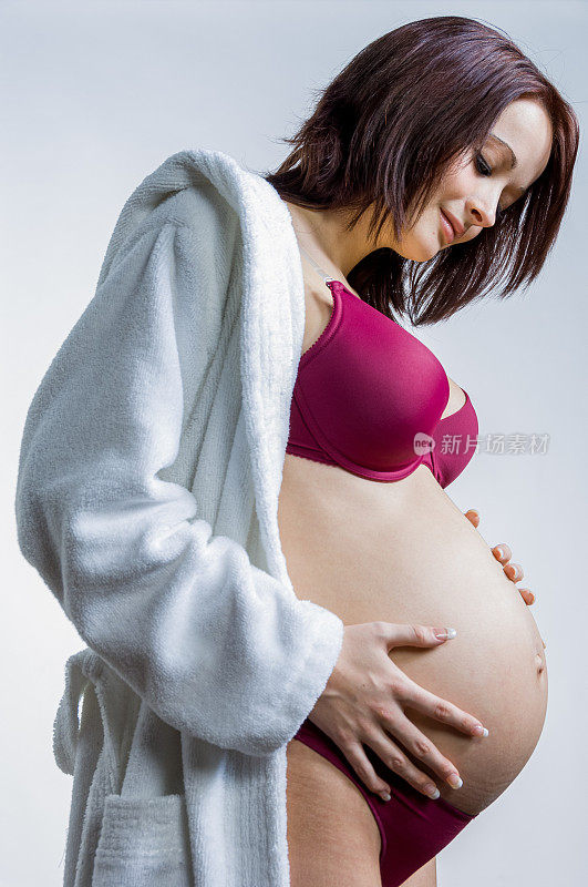 怀孕的年轻女子摸她的肚子