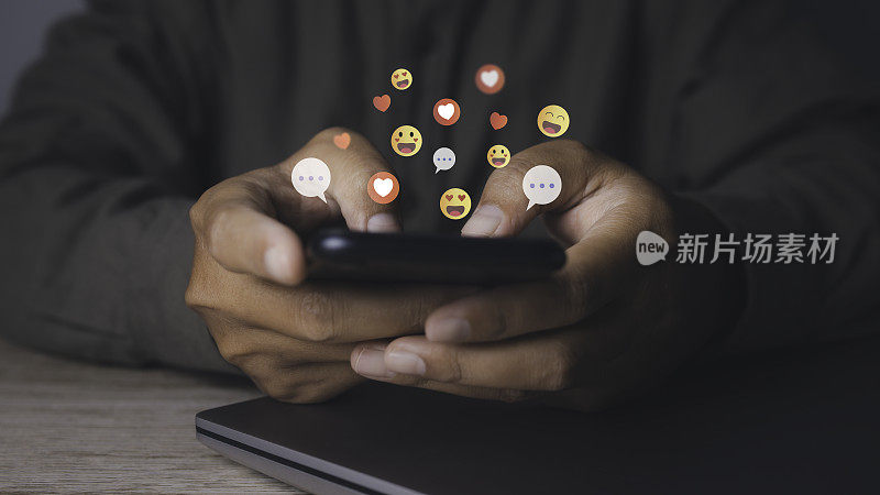 一名男子用带有社交媒体的智能手机在互联网帖子上点赞和爱的图标。