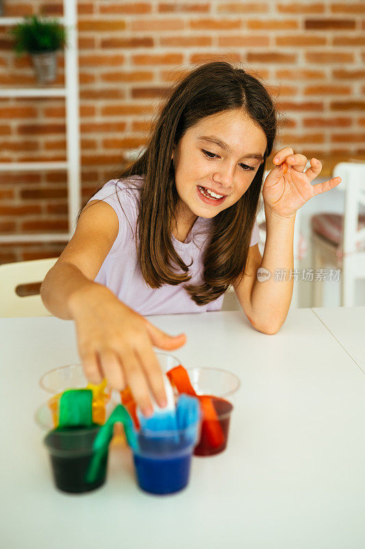 小女孩在家用水和纸做彩虹食物颜色实验
