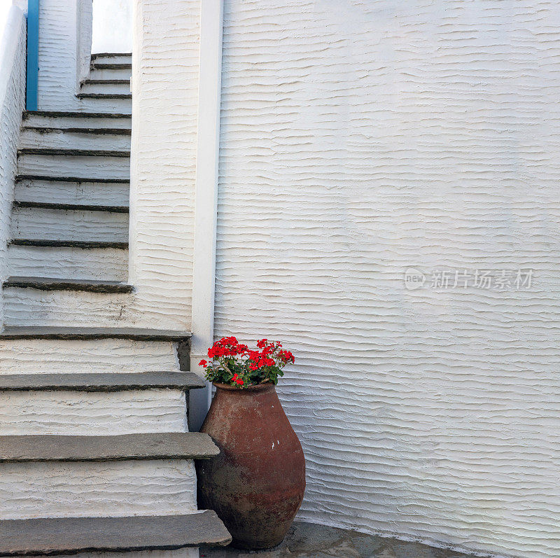 传统的基克拉迪岛石楼梯白色的空墙，花在双耳希腊文化，空间