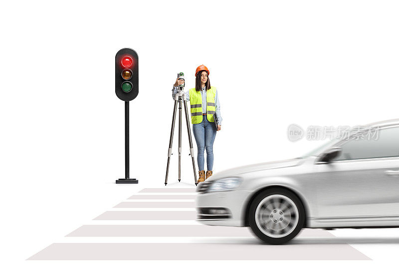 手持测量装置的女大地测量师在红绿灯前等候