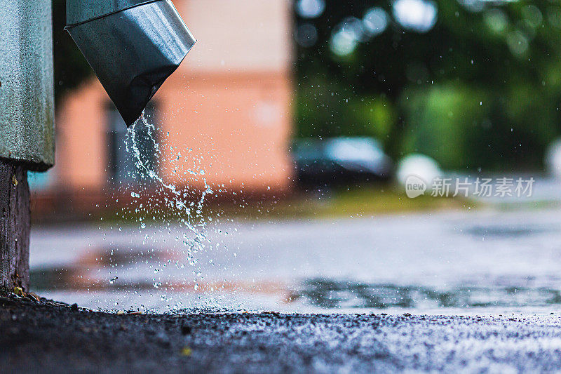 浪费了雨水。水管。洪水。暴雨。多雨的天气。水滴。雨滴。排水