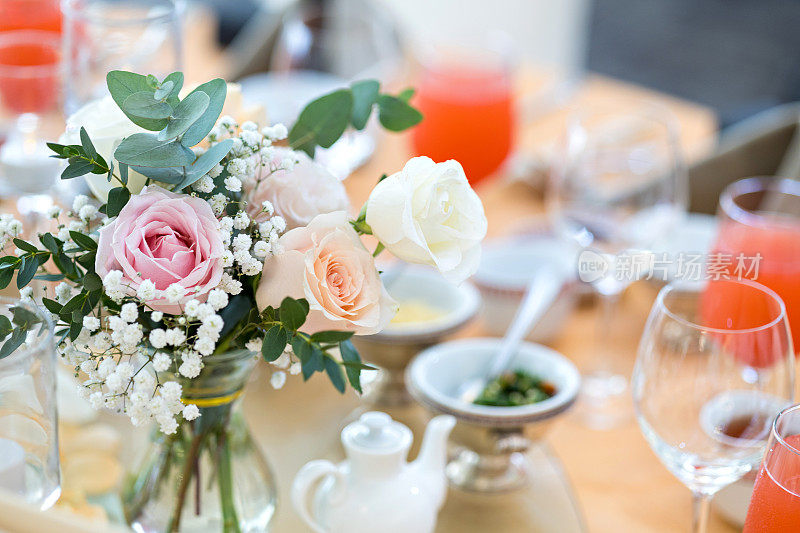 圆桌上摆放着亮闪闪的餐具和玻璃杯，准备参加婚礼