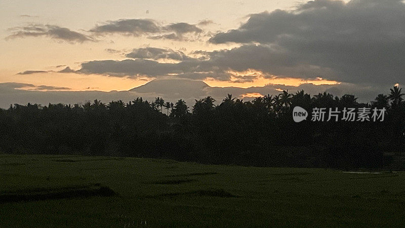 日出时巴厘岛乌布稻田里的火山