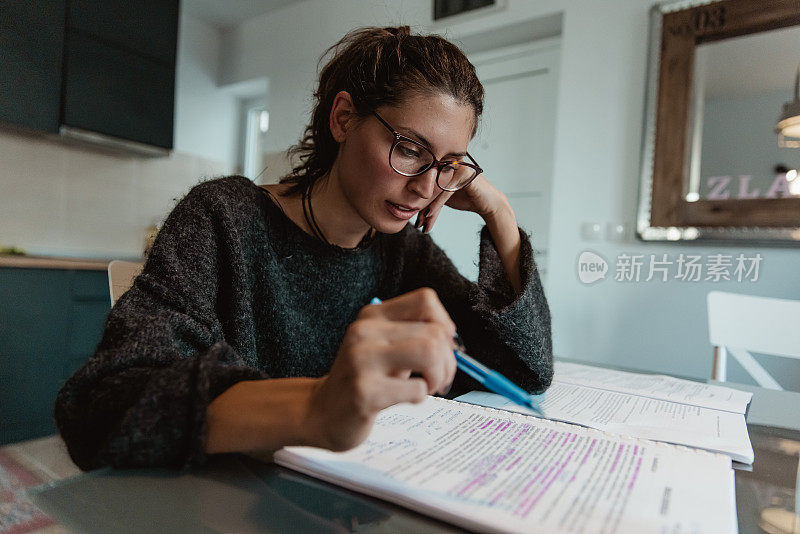 一个可爱的小女孩正在家里准备一场极具挑战性的大学考试。-库存照片