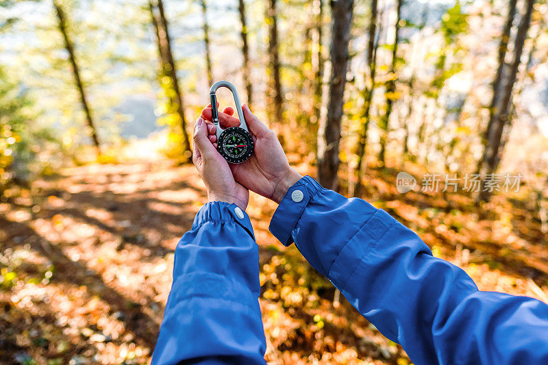 徒步旅行路线上拿着指南针的女人的手