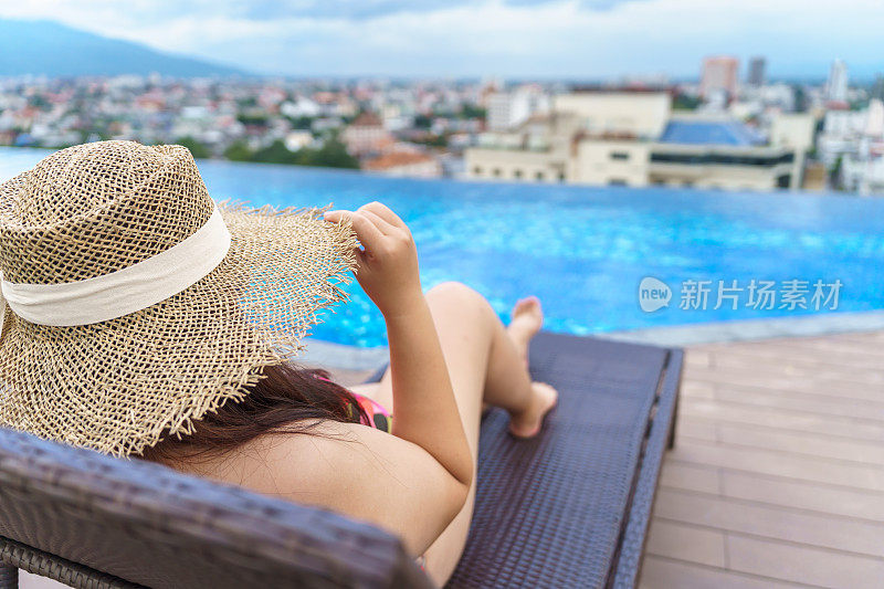 超重的年轻女子橙色swimsuitÂ和稻草沙滩太阳帽在游泳池放松快乐加上尺寸的女人身体积极假期旅行在夏天。