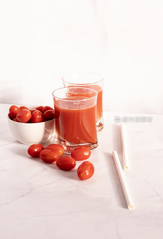 杯子里的番茄汁和新鲜番茄。在白色的背景上。食物