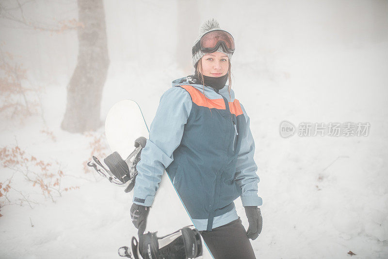 一个微笑的女人准备在山上滑雪的肖像