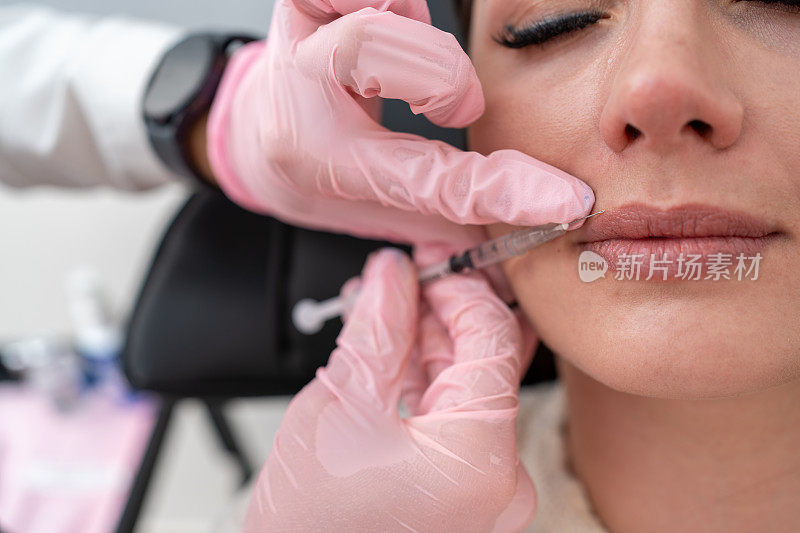 特写:美丽的病人正在接受女医生在嘴唇上注射肉毒杆菌，以美容和护肤