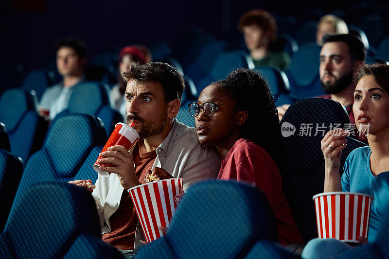 年轻夫妇在电影院看悬疑电影。