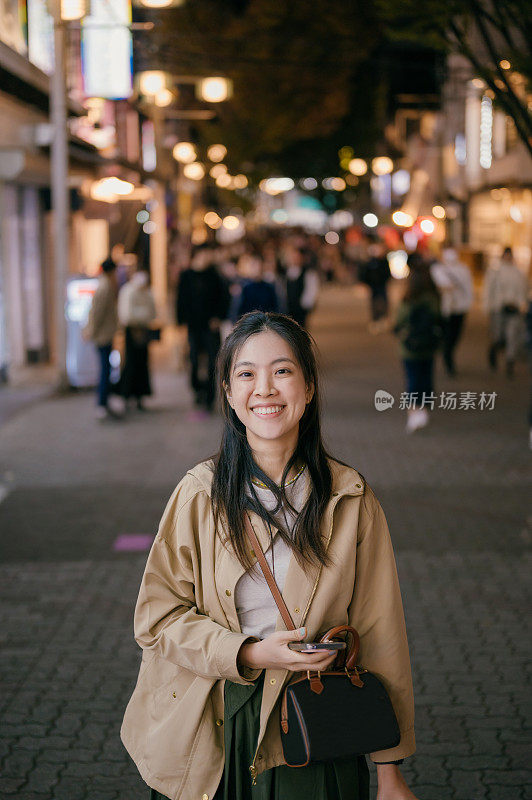 前往东京和大阪市旅游的亚洲女游客四处走走，她对这次旅行感到很开心