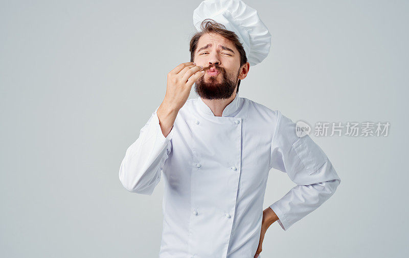 穿着工作服的男人在烹饪专业的头饰，香味扑鼻的食物