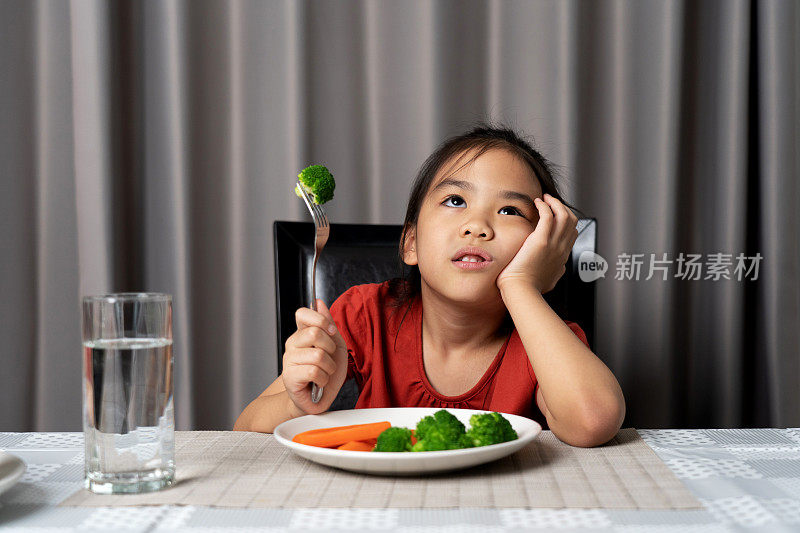 可爱的小女孩拒绝吃健康的蔬菜。孩子们不喜欢吃蔬菜。