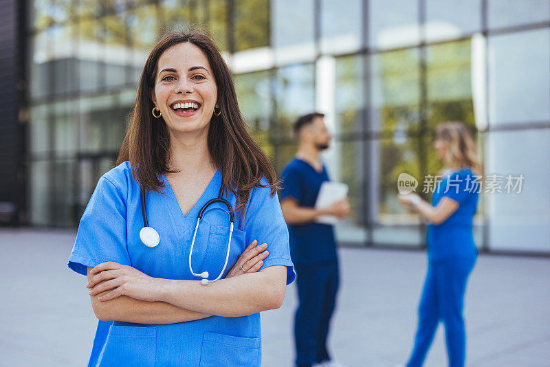医院外穿着蓝色工作服微笑的女护士
